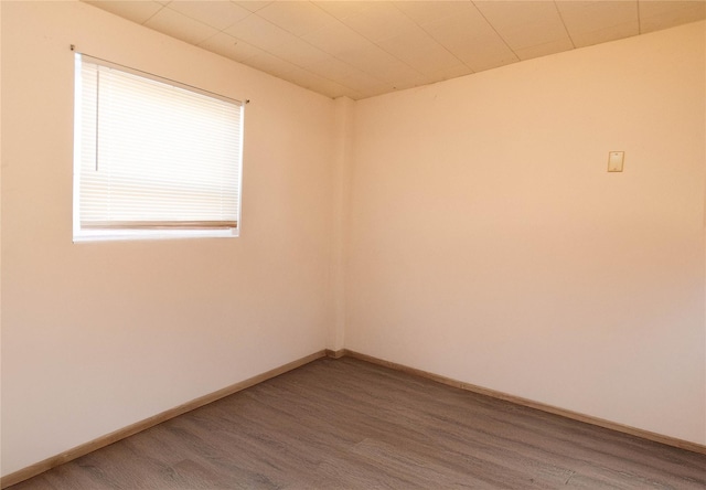 empty room with baseboards and wood finished floors