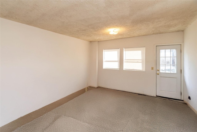 unfurnished room with light carpet and a textured ceiling