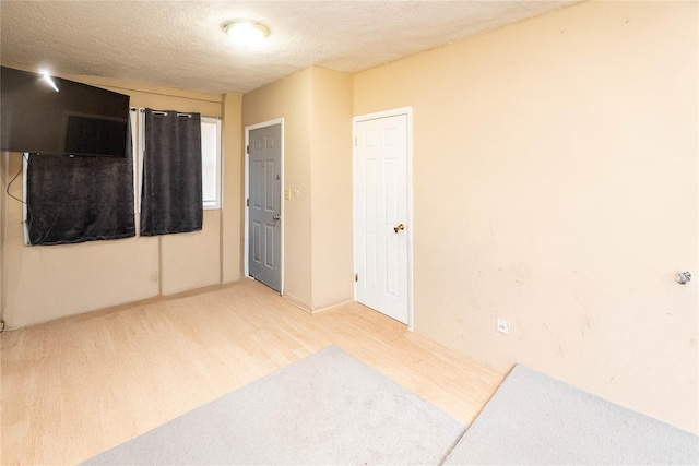 spare room featuring a textured ceiling and wood finished floors