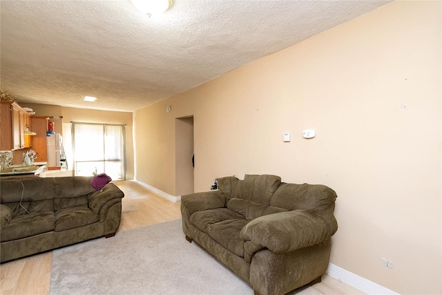 living room with baseboards, a textured ceiling, and light wood-style floors