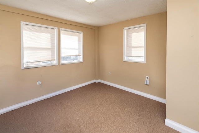 empty room featuring baseboards and carpet floors