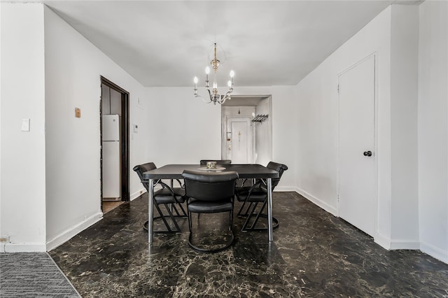 dining room with a chandelier and baseboards