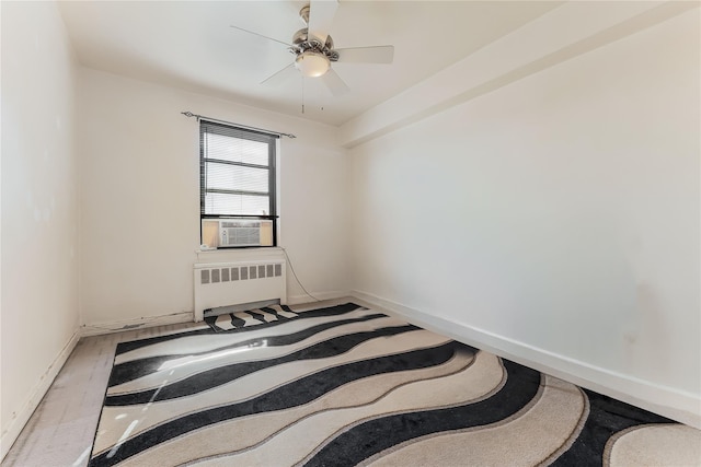 empty room featuring radiator heating unit, cooling unit, a ceiling fan, and baseboards