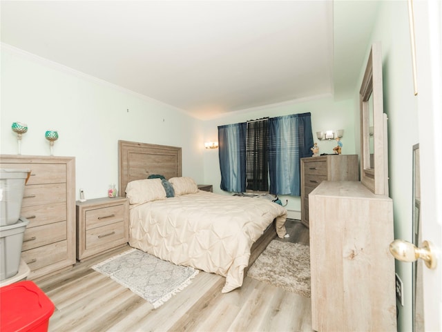 bedroom with crown molding and wood finished floors