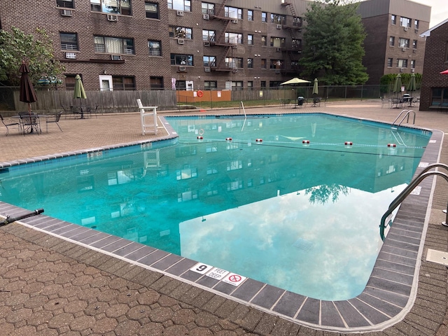 view of swimming pool with a patio and fence