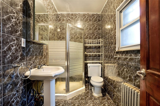 full bath featuring toilet, a stall shower, tile walls, and radiator