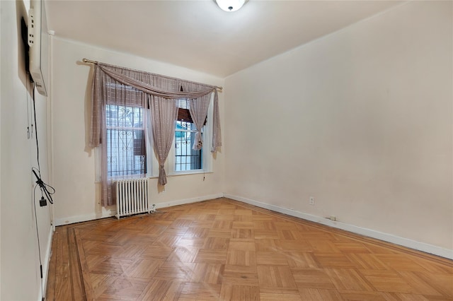 empty room with radiator heating unit and baseboards