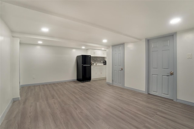 unfurnished living room featuring recessed lighting, light wood-type flooring, and baseboards