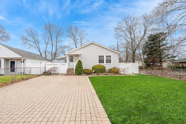 view of front of property with a fenced front yard, a gate, decorative driveway, and a front lawn