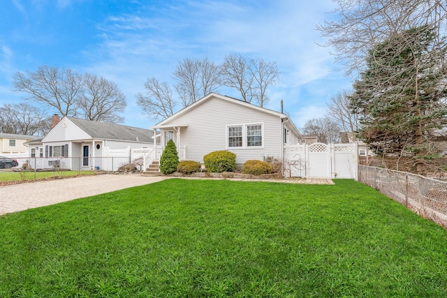 exterior space featuring fence private yard, a gate, a front lawn, and decorative driveway