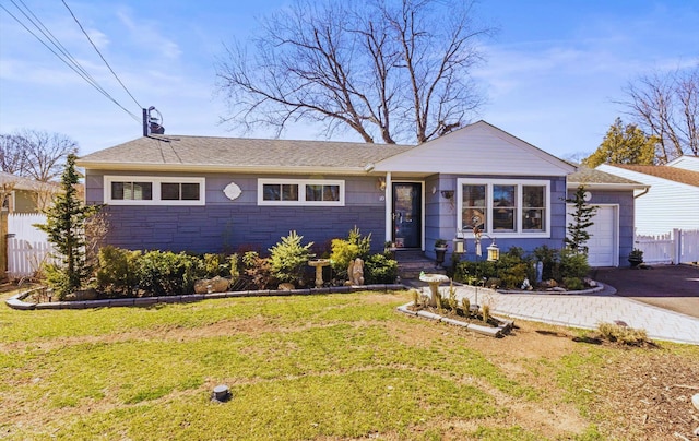 ranch-style house with an attached garage, a front lawn, fence, stone siding, and driveway