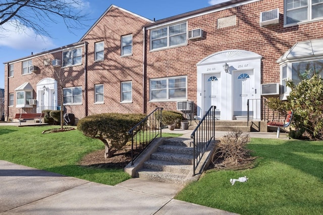 multi unit property featuring brick siding and a front lawn