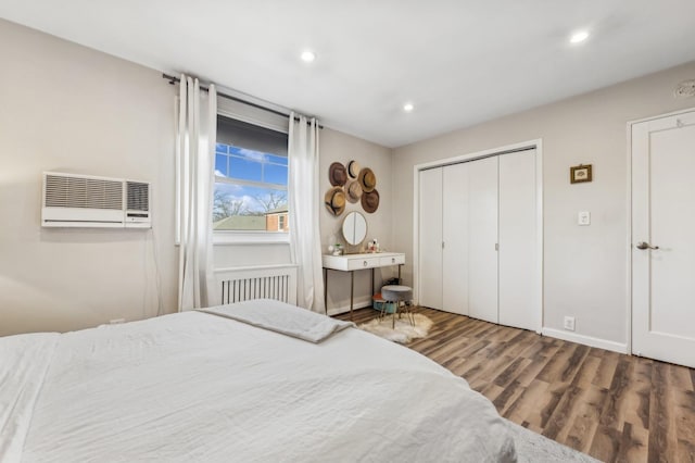 bedroom with baseboards, an AC wall unit, wood finished floors, and recessed lighting