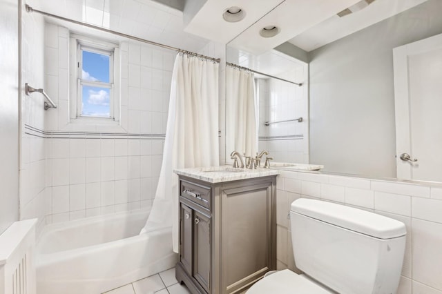 full bathroom with toilet, vanity, tile walls, tile patterned floors, and shower / tub combo with curtain