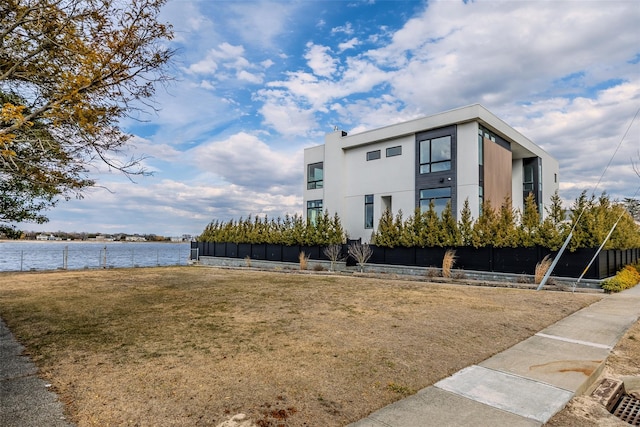 exterior space featuring a water view and fence