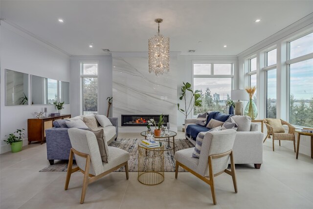 living room with recessed lighting, plenty of natural light, a high end fireplace, and crown molding