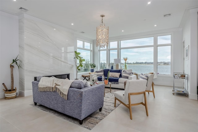 living area with a water view, a notable chandelier, visible vents, and crown molding