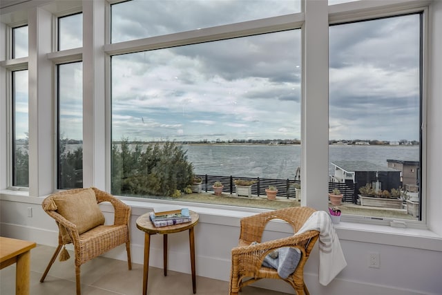 interior space with a healthy amount of sunlight, a water view, and tile patterned flooring