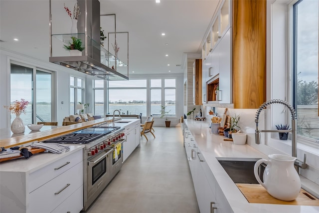 kitchen featuring range with two ovens, white cabinets, island exhaust hood, and modern cabinets