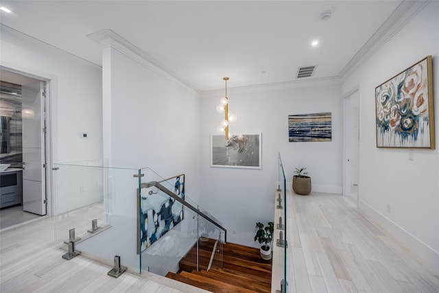 stairway with baseboards, visible vents, wood finished floors, and ornamental molding