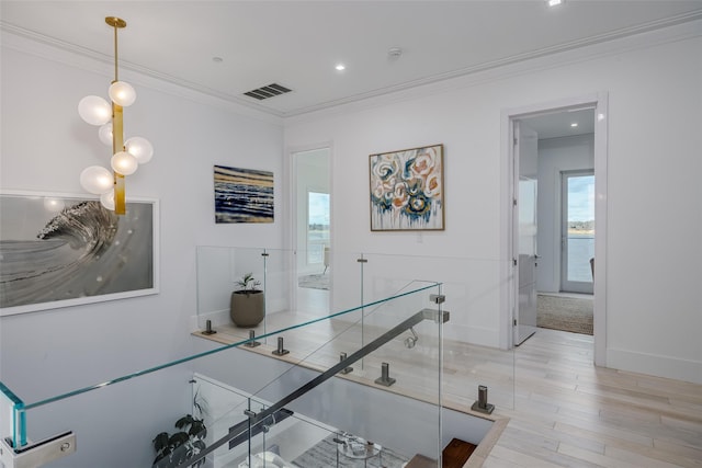 hall featuring baseboards, visible vents, crown molding, light wood-style floors, and recessed lighting