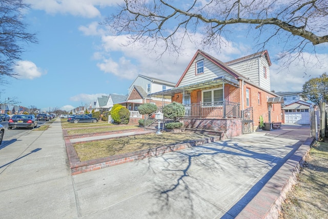 bungalow-style house with brick siding, a porch, and an outdoor structure