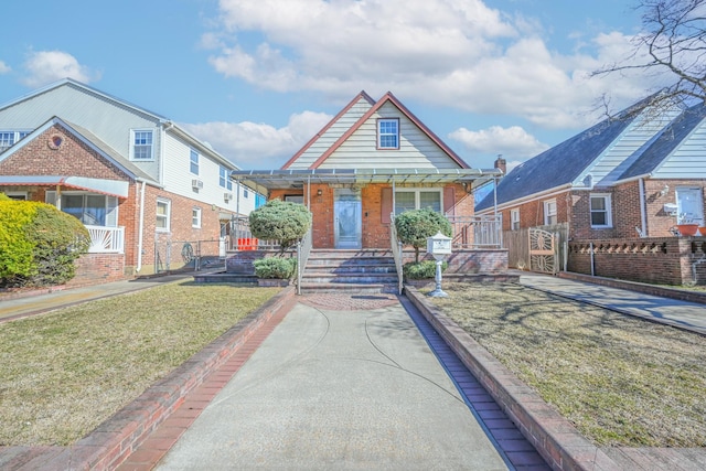 view of front of property with a porch, brick siding, and a front lawn