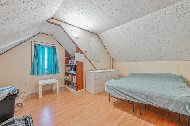 bedroom featuring light wood-type flooring and vaulted ceiling