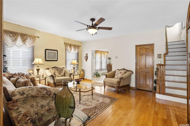 living room featuring ceiling fan, stairway, and light wood-type flooring