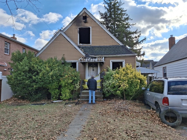 bungalow featuring roof with shingles