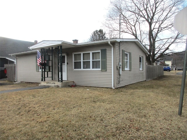 view of front of home with a front yard, fence, and a chimney