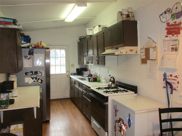 kitchen featuring under cabinet range hood, light wood-style floors, light countertops, and gas range gas stove