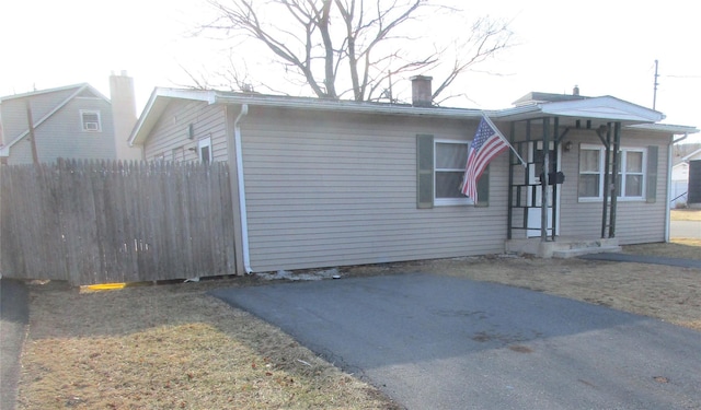 view of front of home featuring a chimney and fence