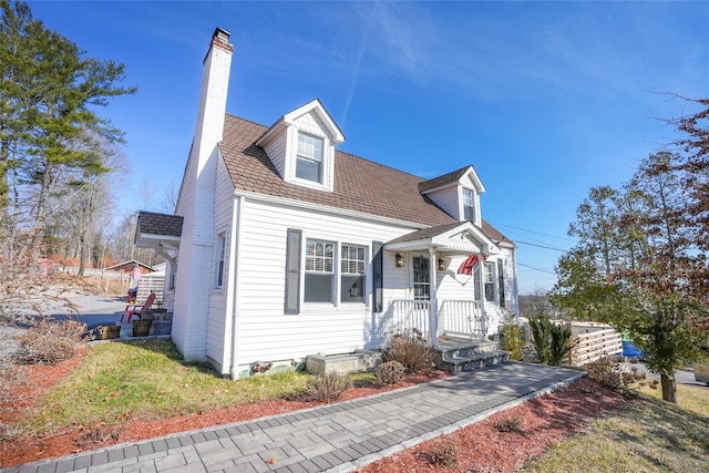 cape cod house featuring a chimney