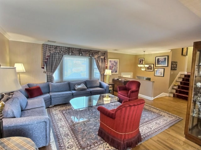 living room with wood finished floors, visible vents, baseboards, ornamental molding, and stairway