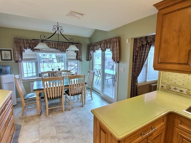 dining space featuring lofted ceiling and visible vents