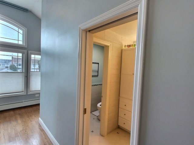 hallway featuring baseboards and wood finished floors