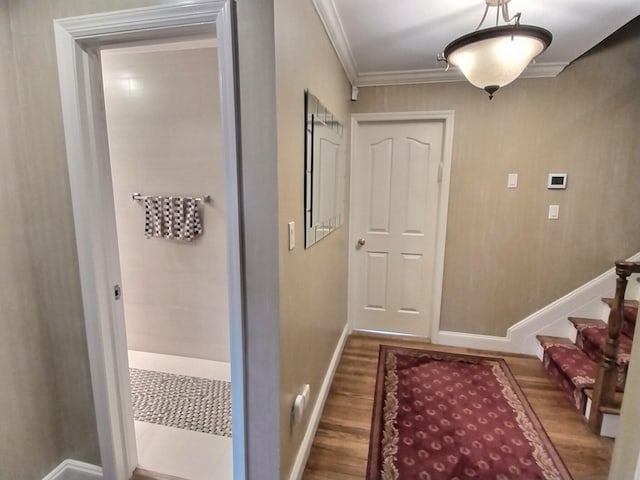 doorway with stairs, baseboards, wood finished floors, and crown molding