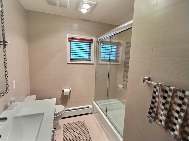 full bath featuring a baseboard radiator, toilet, a sink, tile walls, and tile patterned floors