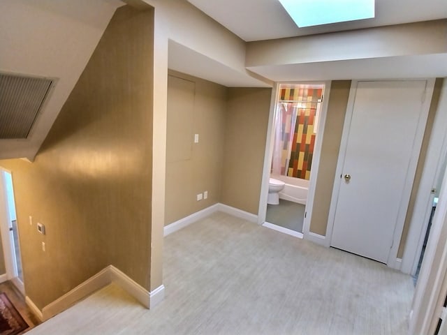 corridor with a skylight and baseboards