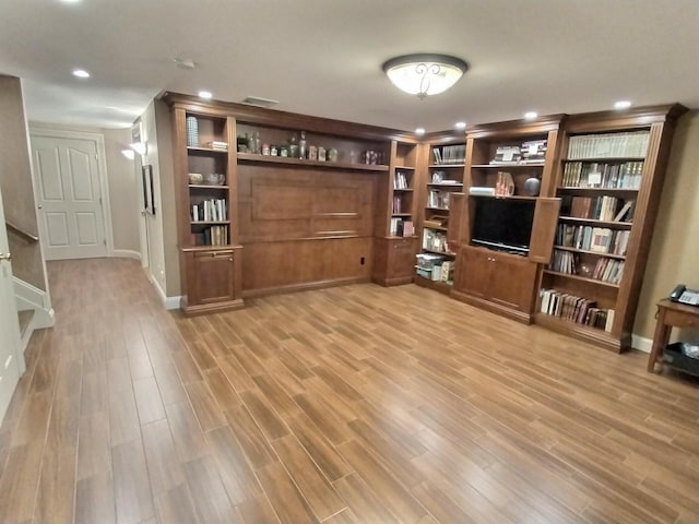 living area with baseboards, light wood-style flooring, and recessed lighting