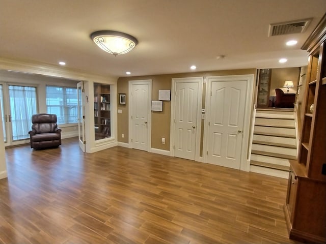 entryway featuring baseboards, visible vents, wood finished floors, stairs, and recessed lighting