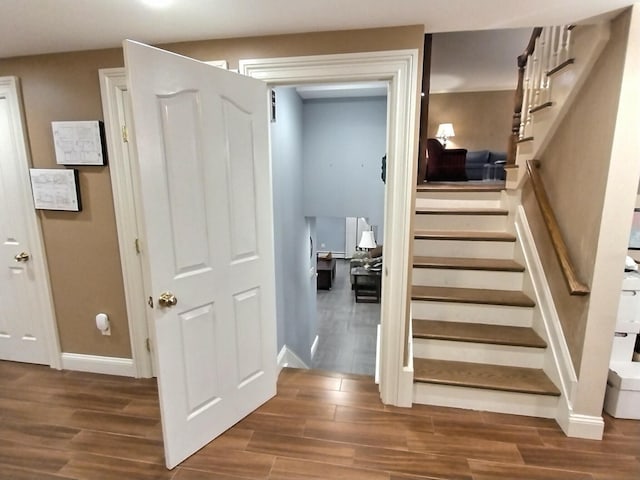 staircase with baseboards and wood finished floors