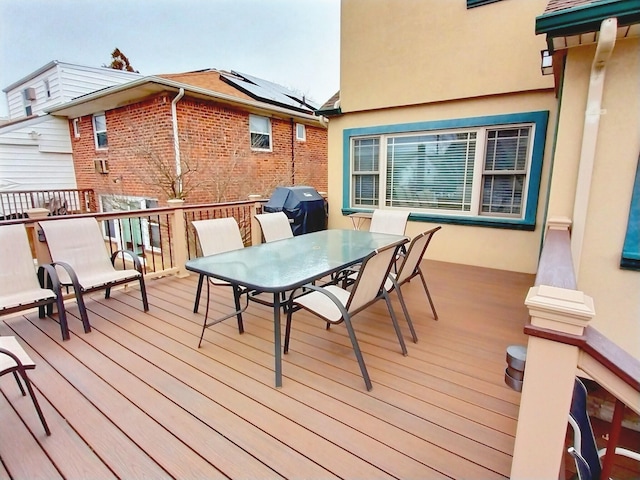 wooden terrace featuring outdoor dining space and area for grilling