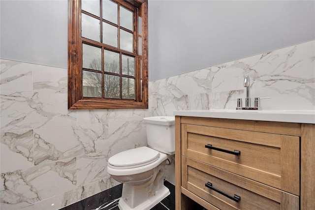 bathroom with a wainscoted wall, toilet, tile walls, and vanity