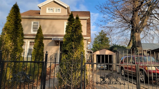 view of front of property with an outdoor structure and fence