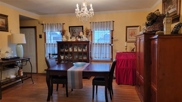 dining room featuring crown molding, an inviting chandelier, and wood finished floors