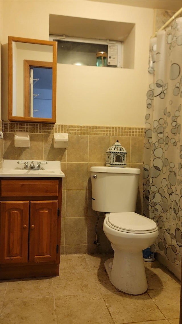 bathroom with curtained shower, toilet, tile walls, and vanity