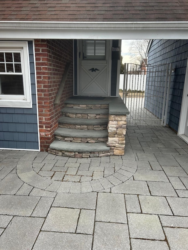 entrance to property with a shingled roof