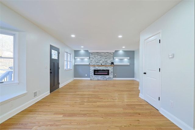 unfurnished living room featuring visible vents, baseboards, recessed lighting, light wood-style flooring, and a fireplace